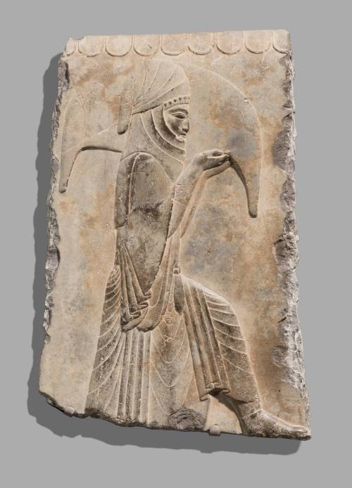 Fragment of a Stone Relief Depicting an Attendant Carrying a Wineskin
