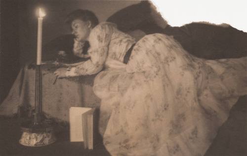 Woman Reclining on a Bed With Candlestick and Book on Floor