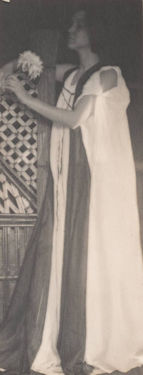 Standing Woman in Medieval Costume Leaning Against Lattice Work, Holding Chrysanthemum