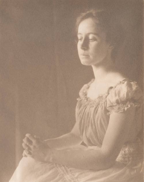 Woman in Short Sleeved Blouse With Hands Clasped on Knees