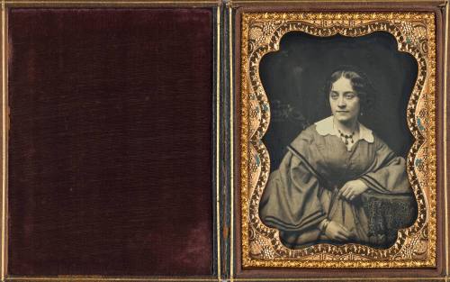 Seated Woman with White Collar Leaning Against a Table