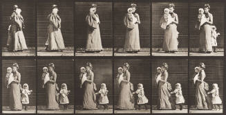 Walking, Carrying a Child, Turning Around; Another Child Holding onto the Woman's Dress